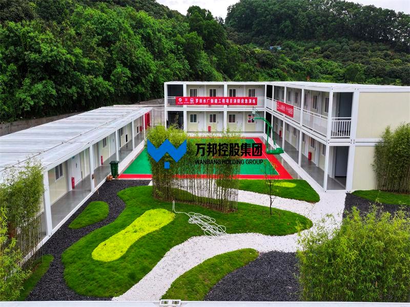 Modular emergency shelter campus with green courtyard and basketball court