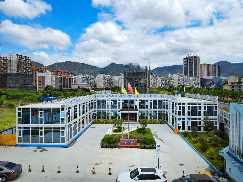 Aerial view of modular campus with white buildings and mountain backdrop